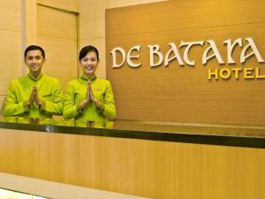 a man and woman standing in front of a hotel at De Batara Hotel in Bandung