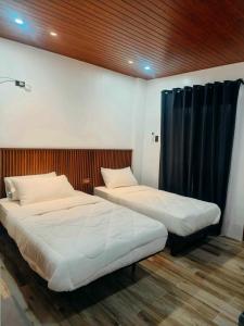 two beds are in a room with at The Annwin Hotel - Sablayan in Sablayan