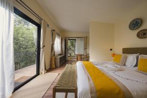 a bedroom with a large bed and a balcony at Pods at Aloe Valley, Ngobit Laikipia in Gatunga