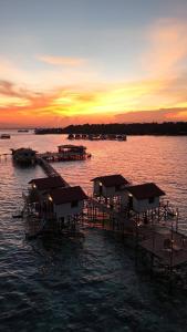 a group of docks in the water at sunset at Coco Seaweed Resort in Semporna +8 photos