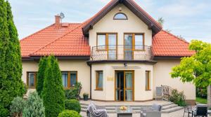 a house with an orange roof at Golden Villas Garden Retreat - Private Garden & BBQ in Kobyłka