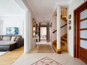 a living room with a couch and a staircase at Golden Villas Garden Retreat - Private Garden & BBQ in Kobyłka