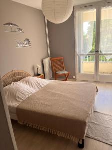 a bedroom with a bed and a chair and a window at Home in Cenon in Cenon