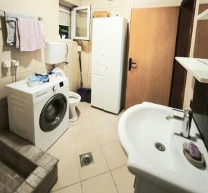 a bathroom with a washing machine and a sink at Spacious City Center Apartment for 6 - Steps from Hilton & Republic Square in Podgorica