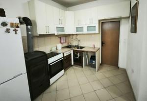 a kitchen with white cabinets and a black stove at Spacious City Center Apartment for 6 - Steps from Hilton & Republic Square in Podgorica