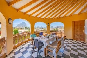 a dining room with a table and chairs on a balcony at Villa Ortembach- PlusHolidays in Ifach