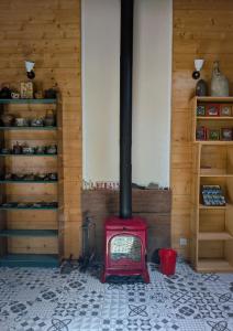 a red stove in a room with wooden walls at LoFt Les Castilléres in Condat-sur-Trincou