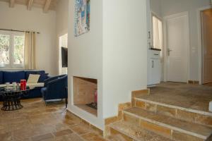 a living room with a fireplace and a blue couch at Charmante petite maison à Corfou in Pelekas