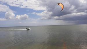 a person kite surfing in the water on the ocean at Domek wakacyjny Bloom in Rewa