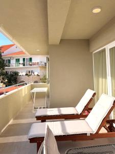a balcony with two lounges and chairs on a balcony at Apartments Paradise Hvar in Hvar