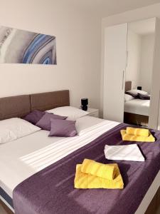 a bedroom with a bed with two yellow towels on it at Apartments Paradise Hvar in Hvar