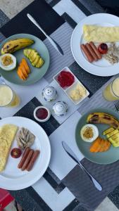 a table topped with plates of food on plates with food at Ora sigiriya Cabana in Sigiriya