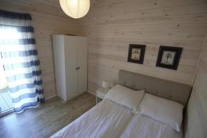 a bedroom with a bed in a wooden wall at Domek wakacyjny Bloom in Rewa