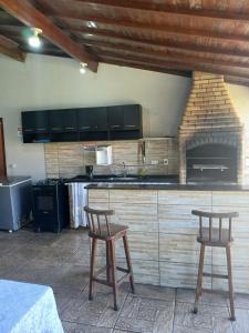 a kitchen with two stools and a counter top at Recanto Lyra in Indaiatuba