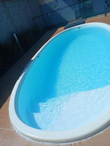 a bath tub with blue water in it at Recanto Lyra in Indaiatuba +3 photos