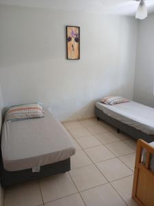 a room with two beds and a picture on the wall at Recanto Lyra in Indaiatuba