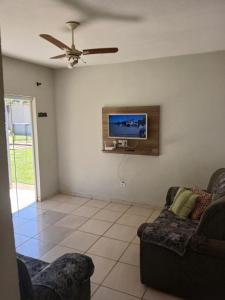 a living room with a couch and a flat screen tv at Recanto Lyra in Indaiatuba