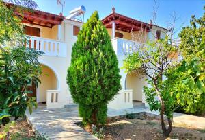 a large white house with trees in front of it at Steni Vala Apartments in Steni Vala Alonissos