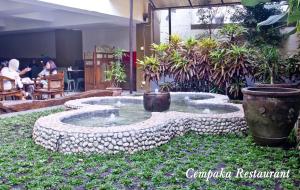 a small pond in the middle of a garden at De Batara Hotel in Bandung
