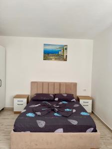 a bedroom with a large bed with purple sheets at Il Sol Apartment in Lezhë