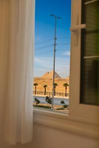 a view of a desert from a window at pyramids view luxury apartment in ‘Ezbet `Abd el-Ḥamîd