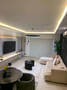 a living room with a couch and a flat screen tv at BelRose Place-East Legon in Otele
