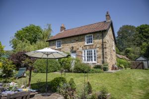 an umbrella in the garden of a house at Virginia Cottage 4 in York