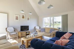 a living room with two couches and a tv at Coldwells Farmhouse in Dalkeith