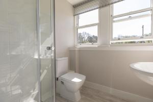 a white bathroom with a toilet and a sink at Coldwells Farmhouse in Dalkeith +8 photos