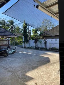 an empty courtyard in a house with a fence at AFWA Surf and Stay in Selong Belanak +8 photos