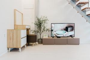 a living room with a tv and a cabinet at Sokcho Night Sky Pension in Sokcho +5 photos