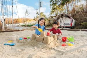 two children playing in the sand on the beach at Sokcho Night Sky Pension in Sokcho