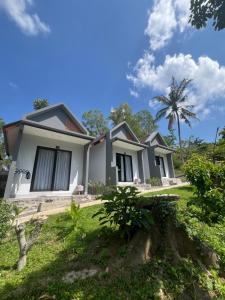 a house with a palm tree in the background at Makarma Resort Lombok in Senggigi