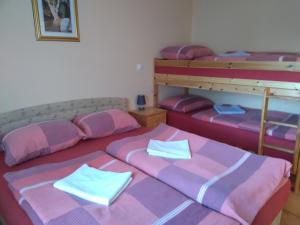 3 camas en una habitación con sábanas rosas y moradas en Apartments and Rooms With View on Bled, en Bled