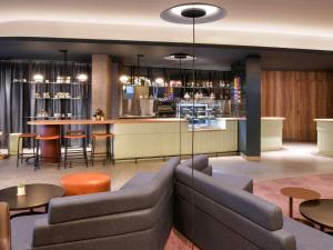 a living room with a couch and a bar at Novotel Kinshasa La Gombe in Kinshasa