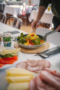 a table with a pan of food and a plate of vegetables at Perła Sudetów by Stay inn Hotels in Karpacz