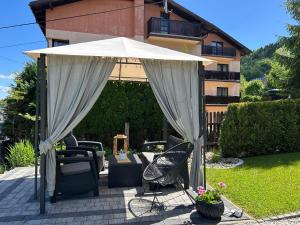 a white umbrella and chairs on a patio at Kwatery u Marysi in Szczyrk