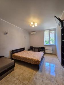 a bedroom with two beds and a table and chairs at ОлександріЯ in Odesa