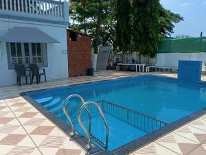 a large swimming pool in a yard with a house at Peace Villa with pool in Murud