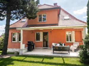 a house with a patio and a grill at Golden Villas Luxury Garden Villa - Kraków in Węgrzce