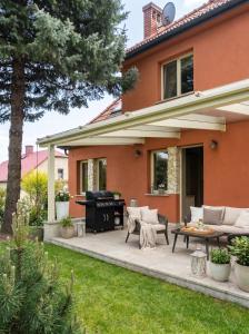 a patio with a grill in front of a house at Golden Villas Luxury Garden Villa - Kraków in Węgrzce