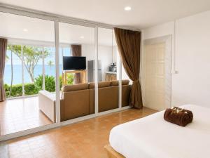 a bedroom with a bed and a couch and a balcony at Bounty Resort in Haad Son