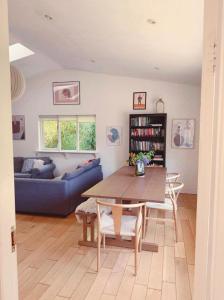 a living room with a table and a blue couch at 2 bed cottage, in the Wicklow Mountains in Tinahely