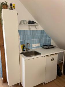 a small kitchen with a sink and a staircase at Green View Apartment in Wülfrath +3 photos