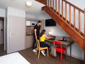 a man and a woman standing at a desk in a kitchen at Adagio Access Lyon Centre Université in Lyon