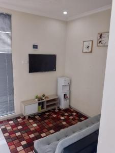 a living room with a couch and a flat screen tv at A-Three Guest House in Malang