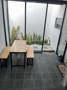 a patio with a table and benches on a balcony at A-Three Guest House in Malang
