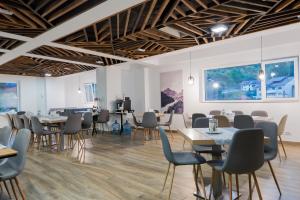 a dining room with tables and chairs and a large window at Hotel Aurora in Băile Olăneşti +56 photos