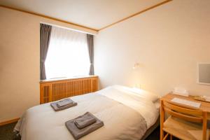 a bedroom with a bed and a desk and a window at べっどぷらす in Wakkanai +17 photos