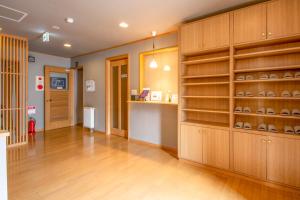 a large room with wooden cabinets and shelves at べっどぷらす in Wakkanai